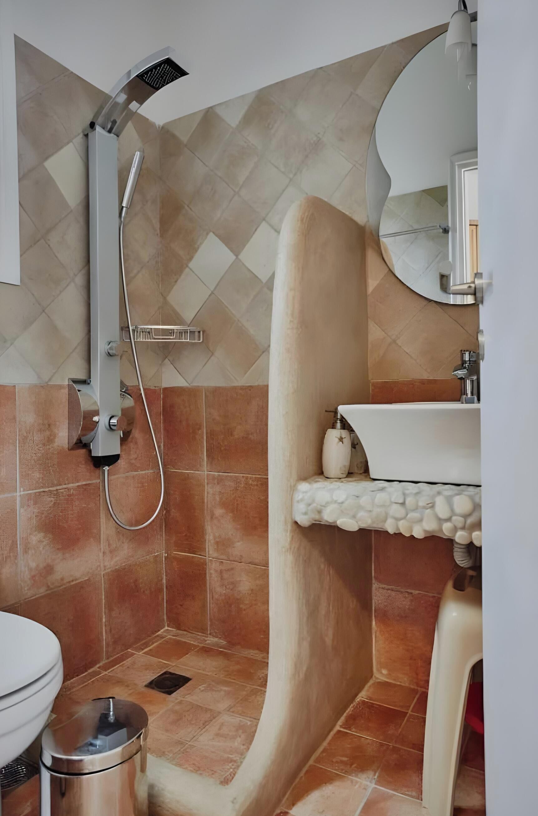 Un baño con ducha, inodoro, lavamanos y espejo.