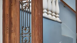 Una porta in legno con un cancello in metallo, una cassetta delle lettere bianca e una scala blu.