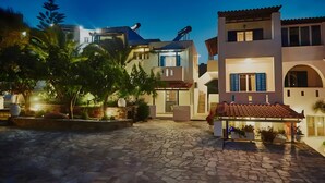 Un cortile con pavimento in pietra, edifici moderni e parabole.