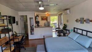 A bedroom with a bed, a desk, a chair, a small table, and a kitchenette. - Cool Loft, King Bed, in Dolega, 10min to David/20min to Boquete. Private Parking (Dolega)