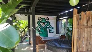 A room with a mural of a frog, a round seating area, and a bamboo fence. - Cool Loft, King Bed, in Dolega, 10min to David/20min to Boquete. Private Parking (Dolega)