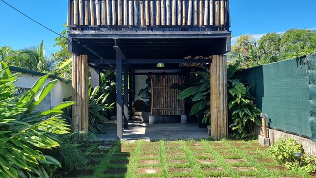 A two-story building with a balcony, surrounded by lush greenery and a paved walkway. - Cool Loft, King Bed, in Dolega, 10min to David/20min to Boquete. Private Parking (Dolega)