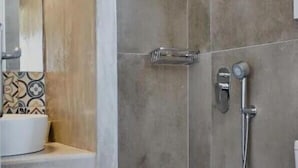 A bathroom with a shower, toilet, and sink.