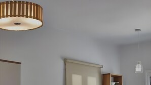 Eine kleine Küche mit Kühlschrank, Spüle, einem Holzschrank und einer Pendelleuchte.