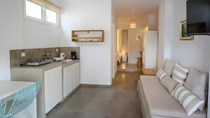 A modern kitchen with a dining area, a sofa, and a TV. - Apartment 'Irene 13 Superior  1' with Sea View, Wi-Fi and Air Conditioning (Andros)