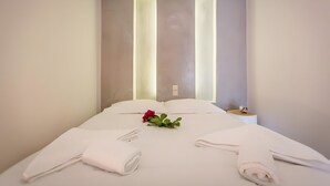 A hotel room with a neatly made bed, a bedside table with a lamp, and a wall-mounted light fixture. - Studio Apartment 'Semi Basement -Superior Apartment' with Mountain View and Air Conditioning (Andros)