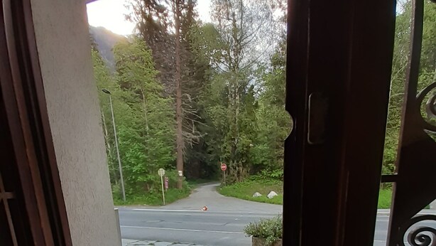 Un camí empedrat de pedra que condueix a una carretera amb un senyal de parada i arbres al fons.