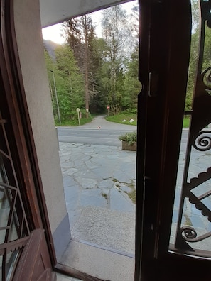 En brobelagt sti der fører hen til en vej med et stopskilt og træer i baggrunden.