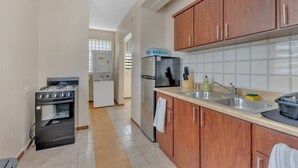 A kitchen with wooden cabinets, a stainless steel sink, a stove, and a refrigerator. - 3-bedroom in superb cozy Arecibo River with WiFi, AC (Puerto Rico)