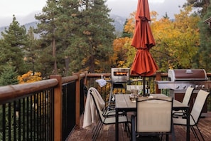 A deck with outdoor furniture, a grill, and a pizza oven.