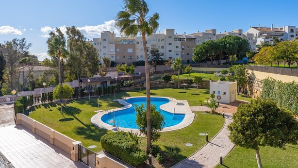 A residential area with a swimming pool, palm trees, and apartment buildings. - Benalmádena-Arenal Golf Apartment with Shared Pool, Wi-Fi, and Air Conditioning (Benalmádena)