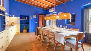 A dining area with a table set for four, wooden chairs, and hanging orange lamps. - Rural House 'Mas Darovie' with Mountain View, Wi-Fi and Air Conditioning (Foixá)