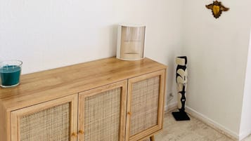 Una habitación con un armario de madera, una obra de arte enmarcada y espejos decorativos en la pared.