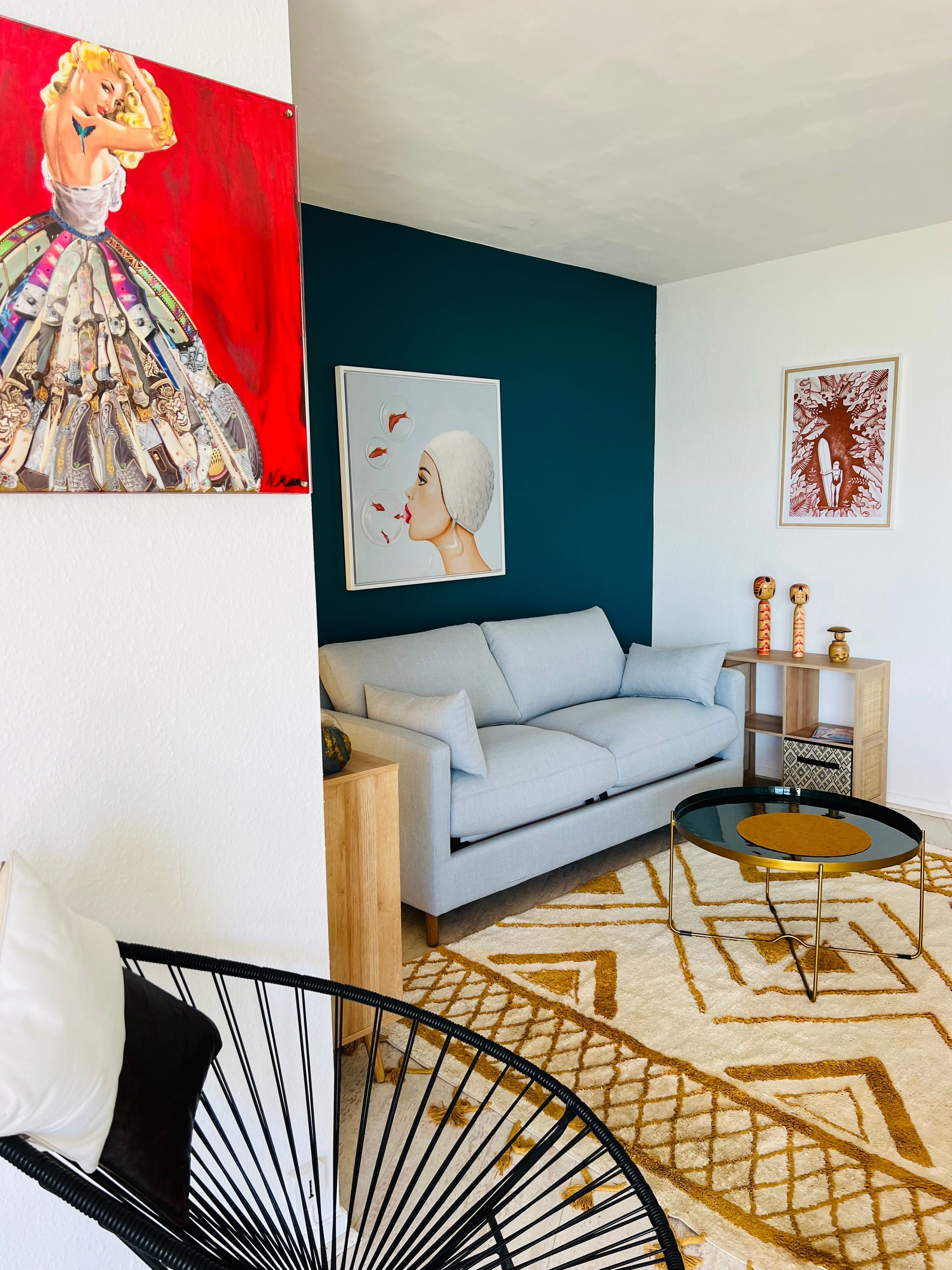 A modern living room with a light blue sofa, a round coffee table, and a patterned rug.