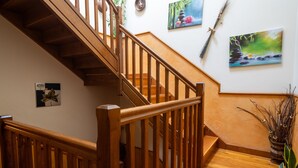 A wooden staircase with a handrail, a wall with framed artwork, and a potted plant. - Country House 'Matxingonea 1' with Mountain View, Private Garden and Wi-Fi (Leorlas)