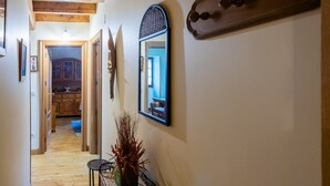 A hallway with wooden floors, a mirror, and a vase with dried plants. - Country House 'Matxingonea 1' with Mountain View, Private Garden and Wi-Fi (Leorlas)