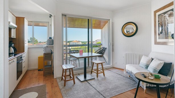 Un espacio habitable compacto con kitchenette, comedor y sofá con vistas.