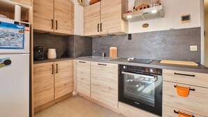 Eine moderne Küche mit Holzausstattung, einem eingebauten Backofen und einer Spüle.