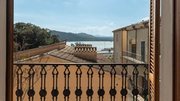 A balcony with a view of a body of water and mountains.