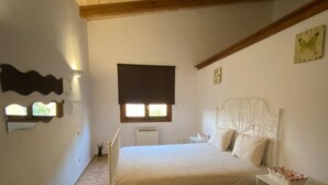 Une chambre à coucher comprenant un lit, une table de chevet, une commode, une fenêtre et un élément décoratif mural.