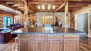 A spacious kitchen with a central island, wooden cabinets, and a rustic ceiling. - Lake View Lodge (Waterfront in Town!) (Greenville)