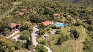 Una propiedad apartada con varias cabañas, una piscina y un jardín bien cuidado.