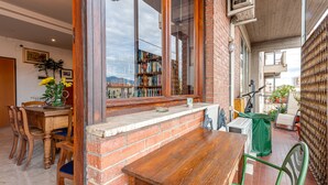 Un área de comedor con pared de ladrillo, mesa de madera y sillas.