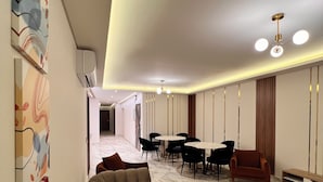 A modern living room with a sectional sofa, a dining table with chairs, and a small coffee table. - White Palace Serviced Apartments (New Cairo)