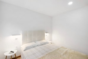 A bedroom with a bed, bedside tables, and a headboard. - Room 'Al Katekero - Quarto 104' with Wi-Fi and Air Conditioning (Gafanha da Encarnação)