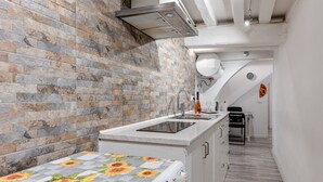A kitchen with a brick wall, a built-in oven, and a sink. - Apartment 'Un Bacio A Firenze' with Wi-Fi and Air Conditioning (Firenze)