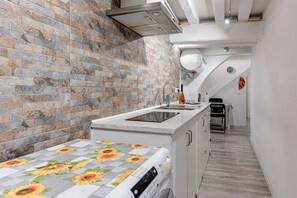 Una cocina con pared de ladrillo, horno empotrado y fregadero.