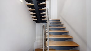 Een moderne spiraaltrap met houten treden en een metalen leuning.