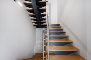 Un escalier en colimaçon moderne, avec des marches en bois et une rampe en métal.