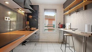 A modern kitchen with a wooden countertop, built-in appliances, and a view through a window.