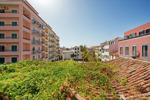 A multi-story building with balconies, a tiled roof, and a garden area in the foreground. - Apartment 'Host Albina' with Private Terrace, Wi-Fi and Air Conditioning (Funchal)