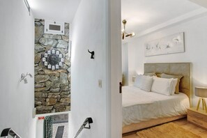 A bedroom with a bed, a nightstand, a wall clock, and a painting. - Apartment 'Host Albina' with Private Terrace, Wi-Fi and Air Conditioning (Funchal)