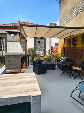 An outdoor patio area with a grill, seating, and potted plants. - Apartment 'Host Albina' with Private Terrace, Wi-Fi and Air Conditioning (Funchal)
