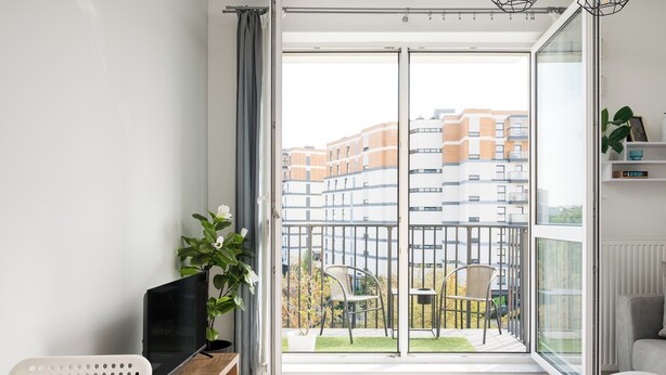 A modern apartment with a balcony, a TV, and a dining area. - Warszawa Rakowska Cosy Apartment (Warszawa)