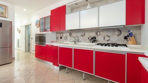 A modern kitchen with red and white cabinetry, a stainless steel refrigerator, a built-in oven, and a gas stove. - Apartment 'Casa Luxury' with Shared Terrace, Wi-Fi and Air Conditioning (Santeramo In Colle)