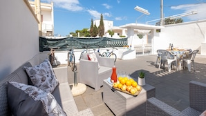 A patio area with wicker furniture, a table with chairs, and a fruit basket. - Holiday Home 'Villa Heart Island Sea View' with Sea View, Wi-Fi and Air Conditioning (Torre Squillace)