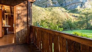 Un balcón de madera con vistas a un paisaje montañoso.