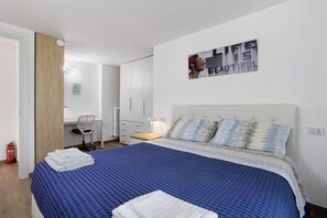 A bedroom with a bed, a desk, a chair, and a wall-mounted artwork. - Apartment 'Suite Strada Persa' with Shared Garden, Wi-Fi and Air Conditioning (Pavia)