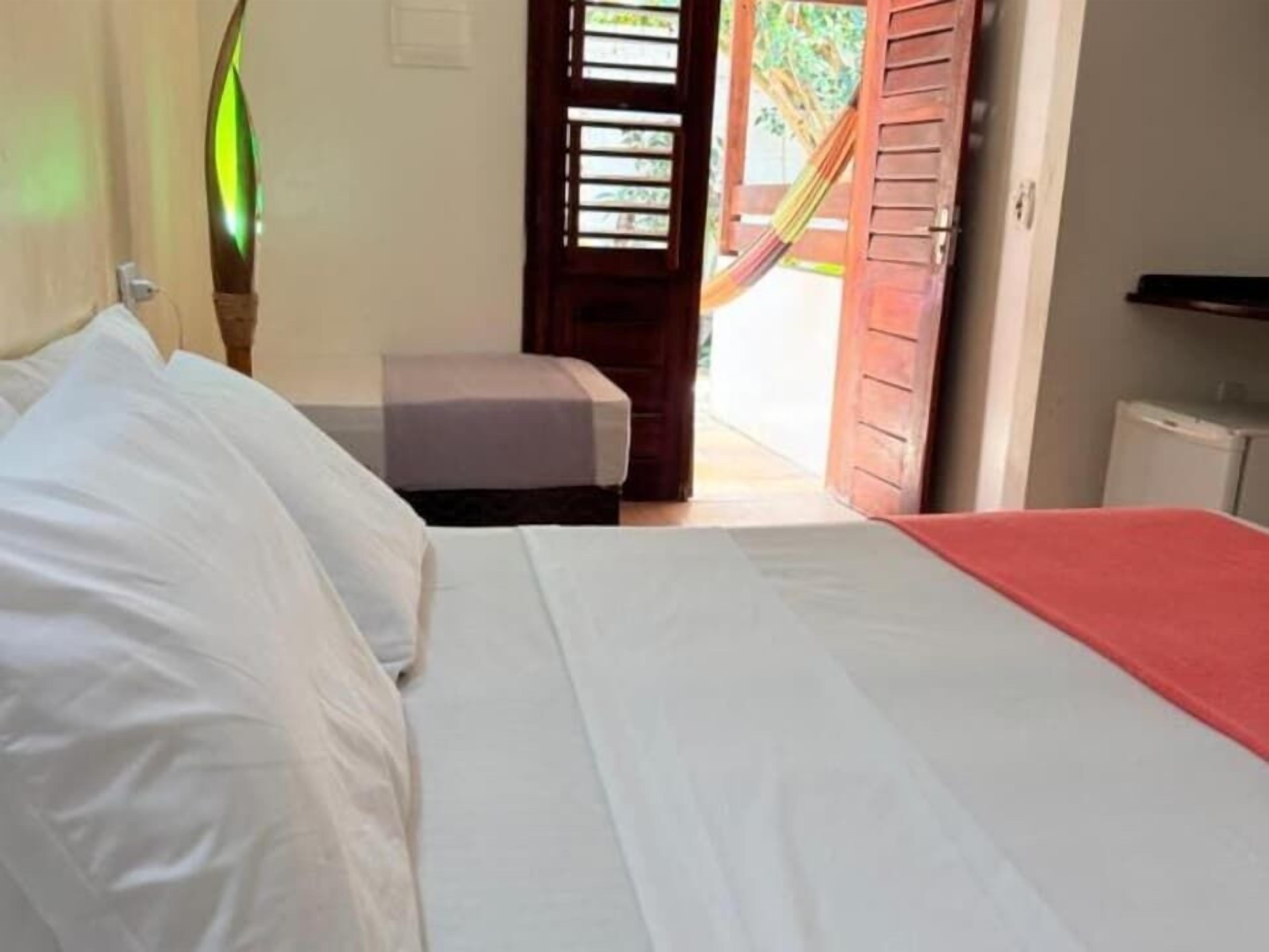 Een slaapkamer met een bed, nachtkastje en uitzicht.
