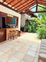 Una zona de recepción con mostrador de madera, un mapa en la pared y una estructura de techo de paja.