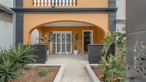 A building entrance with an archway, potted plants, and a gated pathway. - Vacation Apartment 'Villa En Las Caletillas' with Sea View, Private Terrace and Wi-Fi (Punta Larga)