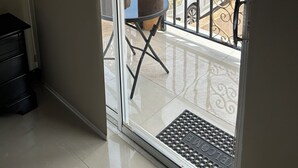 A view from a balcony with a glass door, a metal railing, and a chair. - Charming 2-bedroom apartment with WiFi, AC in wonderful Kingston (Kingston)