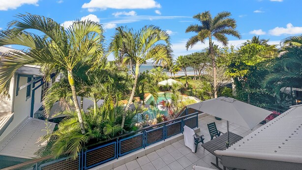 A rooftop terrace with a pool, palm trees, and a view of the ocean. - Wongalinga Beachfront Apt 5 (Wongaling Beach)