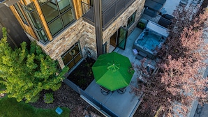 Un edificio moderno con un patio, una bañera de hidromasaje y asientos al aire libre.