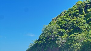 Formación rocosa natural con una abertura similar a una cueva, rodeada de olas marinas.