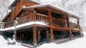 A wooden cabin with a snow-covered balcony and a porch. - 20 min to Yellowstone, Family Cabin, Fire Pit (Island Park)